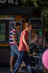 Фото тату: минималистичный рисунок ветвей дерева в черном цвете на плече мужчины. Татуировка выполнена тонкими линиями, видны детали рисунка.