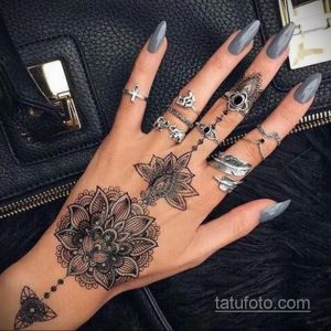 Фото тату: сложный кружевной узор, выполненный в технике blackwork, покрывает руку от запястья до пальцев.