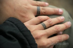 Фото тату: черные геометрические полосы, имитирующие кольца, нанесены на пальцы рук. Минималистичный дизайн.