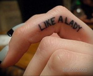 Фотография минималистичной татуировки 'Like a Lady' на пальце руки. Текст, выполненный тонким шрифтом, выглядит элегантно и стильно.