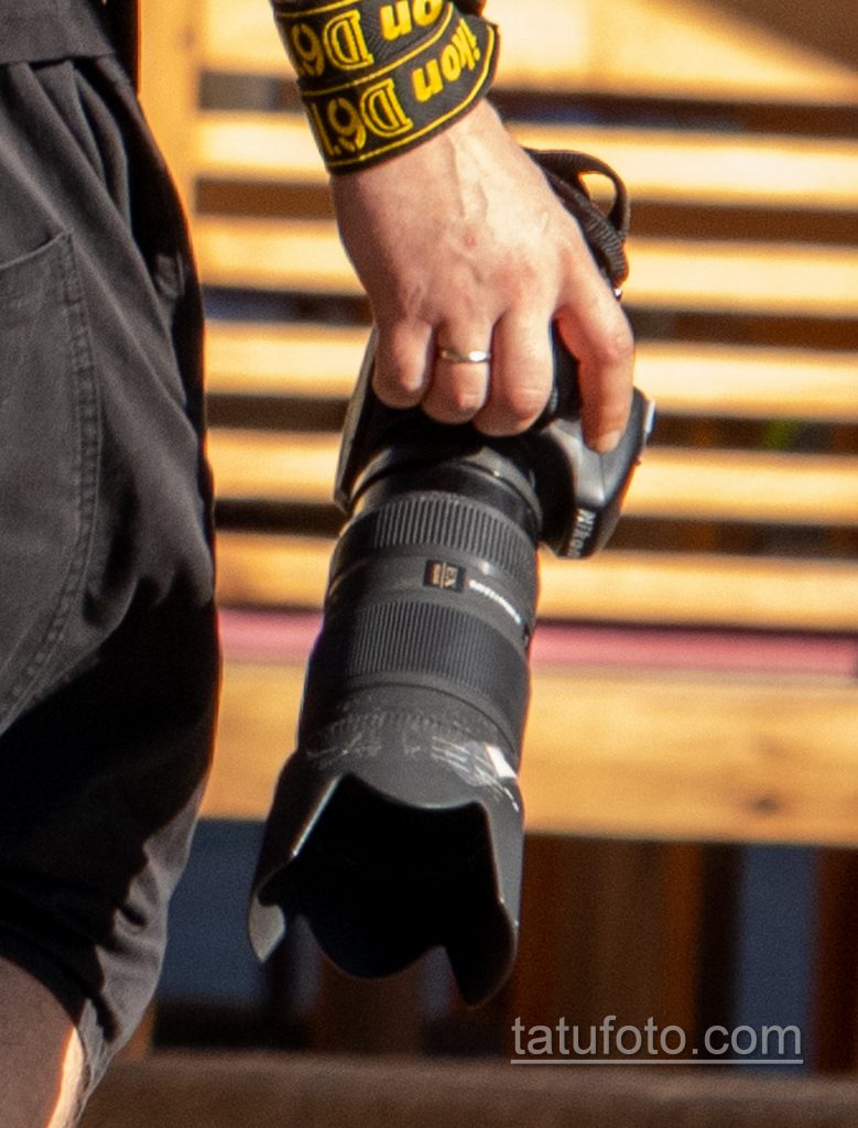 Фото тату с маори узорами и надписями на руке парня с фотоаппаратом Никон в руке девушки - Уличная татуировка 14.09.2020 – tatufoto.com 5