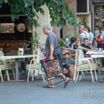 Фото уличного художника который несет картины и стул – Уличная татуировка 14.09.2020 – tatufoto.com 5