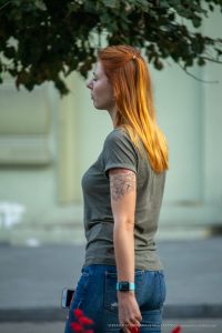 Фотография девушки с татуировкой цветка на руке. Татуировка выполнена в черных тонах и имеет детализированный рисунок.
