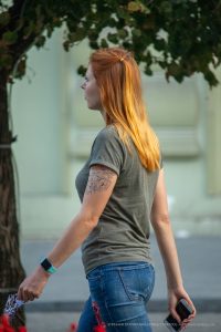 Фотография девушки с татуировкой цветка на руке. Татуировка выполнена в черных тонах и имеет детализированный рисунок.