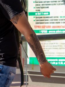Крупный план татуировки на руке, изображающей здание или архитектурный элемент. Детализированный рисунок выполнен в черных тонах.