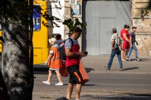 Фото тату на плече мужчины. Яркий рисунок в виде узора или символа, выполнен в красочных тонах.