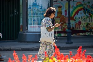 Фото девушки с татуировкой на руке, изображающей цветочный узор и абстрактные элементы. Тату выполнено в ярких, насыщенных цветах.