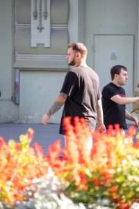 Фото тату: рука мужчины с татуировкой карпа кои в ярких цветах. Детализированный рисунок и динамичная композиция.