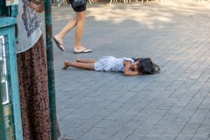 Фотография уличной татуировки: мужчина с татуировкой на руке идет по улице, мимо прохожих.