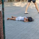 Фотография уличной татуировки: мужчина с татуировкой на руке идет по улице, мимо прохожих.