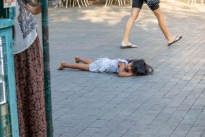 Фотография уличной татуировки: мужчина с татуировкой на руке идет по улице, мимо прохожих.
