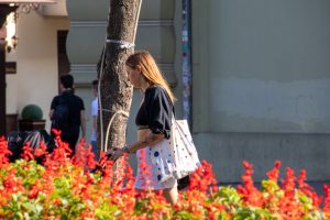 Фото тату на руке девушки, держащей сумку. Татуировка выполнена в минималистичном стиле, изображает абстрактные узоры и геометрические фигуры.