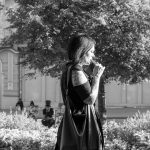 Фото татуировок на руках женщины в черной одежде. Татуировки выполнены в темных тонах, изображают растительные мотивы и абстрактные узоры.