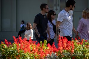 Фотография татуировки на руке, выполненной в абстрактном стиле. Черно-серый рисунок расположен на фоне ярких красных цветов.