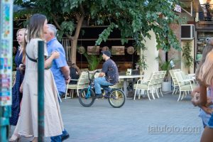 Фото тату на руке мужчины: небольшая татуировка, яркие цвета, абстрактный рисунок, стиль олдскул, татуировка на запястье.