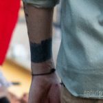 Детальное фото татуировки на внутренней стороне руки мужчины. Виден темный, абстрактный рисунок, выполненный в технике блэкворк.