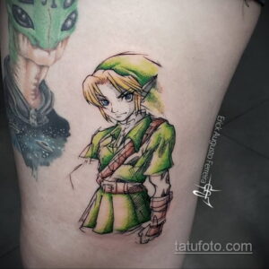 Фото тату: реалистичный портрет Линк из The Legend of Zelda, выполненный в акварельной технике. Яркие цвета, детализированная прорисовка.