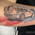 Фото тату DeLorean из фильма 'Назад в будущее' на предплечье, с яркими красными и синими следами скорости, выполненное в реалистичном стиле.