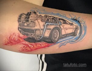 Фото тату DeLorean из фильма 'Назад в будущее' на предплечье, с яркими красными и синими следами скорости, выполненное в реалистичном стиле.