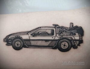 Четкая черно-белая татуировка на руке с изображением DeLorean из фильма 'Назад в будущее', с детальной проработкой корпуса и футуристических элементов.