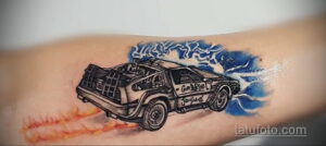 Фото тату: Татуировка DeLorean с изображением молний и огня. Черно-белый рисунок с яркими акцентами. Динамичный стиль.