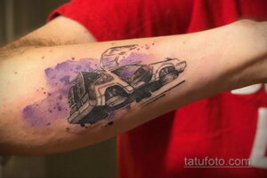 Фото тату на руке: автомобиль DeLorean из фильма 'Назад в будущее', выполненный в стиле акварели. Размытые линии и нежные оттенки.