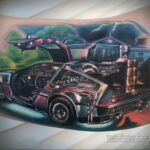Фото тату DeLorean DMC-12 из фильма 'Назад в будущее' на руке. Детализированный рисунок татуировки с реалистичной проработкой деталей автомобиля и эффектом движения.