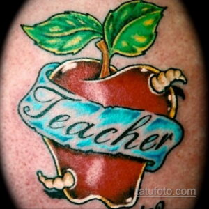 Фото татуировки красного яблока с надписью 'Teacher' на голубой ленте, выполненной в ярком и красочном стиле.
