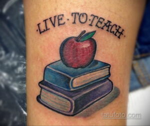Фото татуировки на руке: красное яблоко лежит на стопке книг. Надпись 'LIVE TO TEACH'.