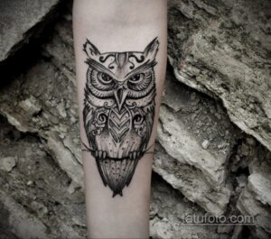 Фото тату с изображением совы, выполненной в стиле графика. Рисунок состоит из множества тонких линий и точек.