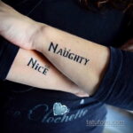 Фото тату на запястьях: парные надписи 'Naughty' и 'Nice', выполненные черным шрифтом. Оригинальный рисунок татуировки.