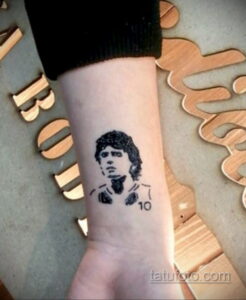 Фото тату: небольшой портрет известного человека на руке. Идеально для поклонников и фанатов.
