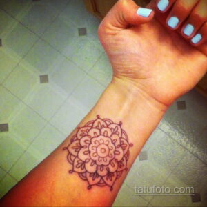 Фото тату хной на запястье с изображением мандалы. Простой и элегантный рисунок в восточном стиле, выполненный коричневой хной.