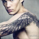 Фото татуировки на плече с изображением крыльев, плавно переходящих в кожу. Реалистичный стиль, эффект объемности.