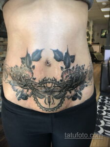 Фото тату с изображением бабочки, роз и цветов на женском животе. Красочный рисунок татуировки с детальной проработкой и яркими красками. Идеальный эскиз тату.
