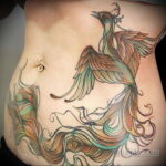 Фото тату на животе: красочный феникс с расправленными крыльями и детализированными перьями. Эскиз тату в стиле ориентал.