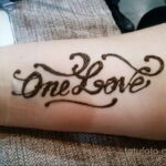 Фото мехенди: Надпись 'One Love' выполненная хной на предплечье. Простой и лаконичный дизайн, восточный стиль.