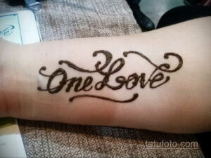 Фото мехенди: Надпись 'One Love' выполненная хной на предплечье. Простой и лаконичный дизайн, восточный стиль.