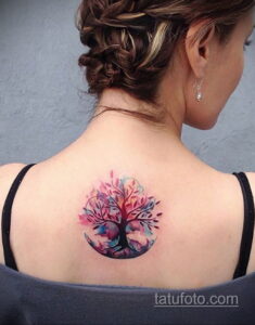 Фото татуировки в стиле акварель с изображением дерева на спине. Изображение выполнено в пастельных тонах с использованием техники размытия.