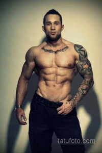 Фото татуировки на мужском теле: татуировка на груди и руке, включающая изображение розы и звезды. Мужчина демонстрирует свою физическую форму.