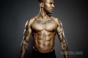 Фото мужчины с атлетичным телосложением и татуировками на руках и груди. Татуировки выполнены в традиционном стиле с использованием черных линий и ярких цветов.