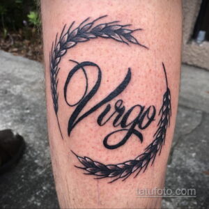 Фото тату надписи 'Virgo' на руке: надпись в каллиграфическом стиле, окруженная колосьями пшеницы, символизирующими знак зодиака Дева.