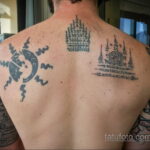 Фотография мужчины с татуировками на спине, включающими изображение солнца и элементы сакральной геометрии, выполненные в черном цвете.