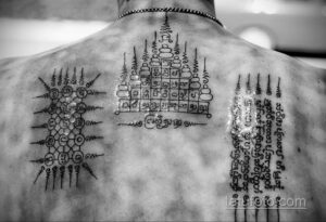 Фотография мужской спины, полностью покрытой детализированной татуировкой сак янт. Видны сложные узоры и символы.