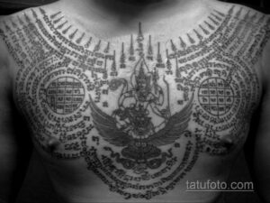 Фото тату: сложный сакральный рисунок сак янт на груди и животе, выполненный черными чернилами. Уникальный эскиз тату для ценителей восточной культуры.