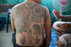 Фото тату: Полностью покрытая татуировками спина мужчины в стиле сакральной геометрии. Черные линии, сложные узоры, религиозные символы.