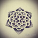 Фотография черно-белой татуировки мандалы, выполненной техникой pointillism (дотворк). Тату выглядит как скопление мелких точек.