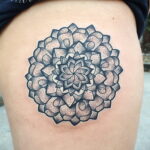 Фото тату: Мандала, выполненная в технике dotwork, на бедре. Использованы только точки для создания рисунка.