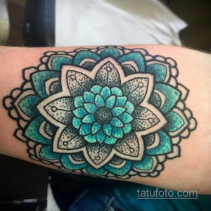 Фото тату: бирюзовая мандала на предплечье, геометрический узор, точечная техника, детализированный рисунок, яркие цвета.