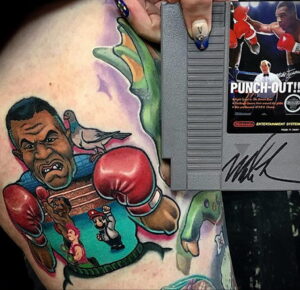 Уникальное фото тату, объединяющее персонажей из игр Mike Tyson's Punch-Out!! и Super Mario Bros. на груди. Детализированный рисунок с использованием ярких цветов и ретро-стиля.